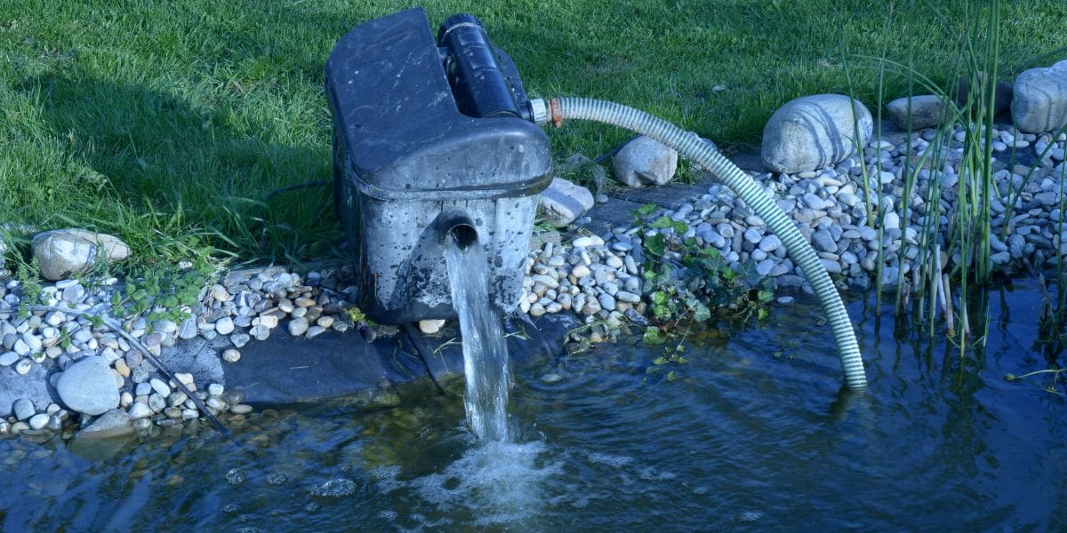 A pond pump with a koi pond in the background